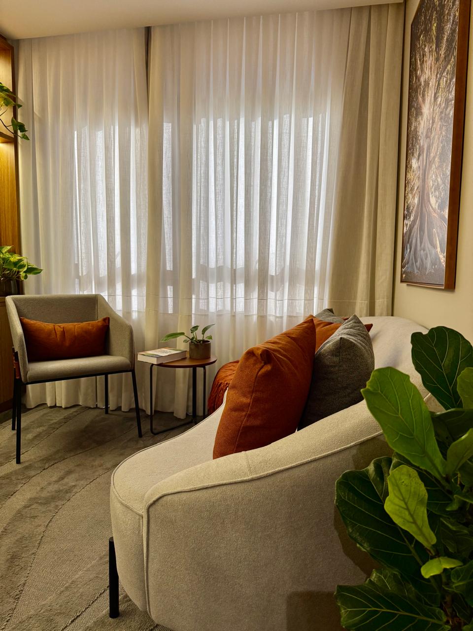 Sala de atendimento com sofá e obra da figueira